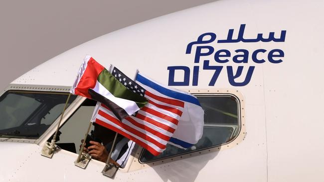 The Emirati, Israeli and US flags are flown from the front of the captain’s pit beside the Arabic, English and Hebrew word for peace. Picture: AFP