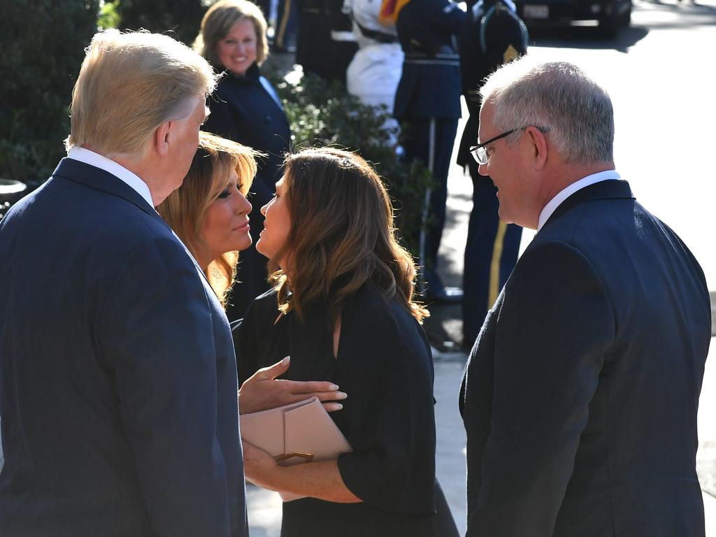 United States President Donald Trump and Australia's Prime Minister Scott Morrison watch wives Melania and Jenny kiss at a ceremonial welcome on the south lawn of the White House in Washington DC, United States. Picture: Mick Tsikas