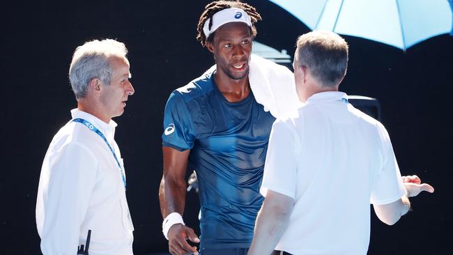 Gael Monfils speaks to tournament officials as he struggled in the extreme heat.