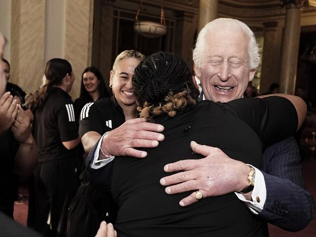 The monarch gets a “healing hug” while meeting New Zealand's Black Ferns rugby union team. Picture: Getty Images