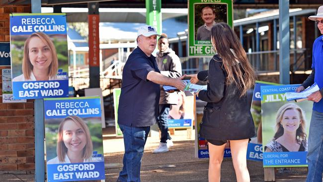 Member for Terrigal Adam Crouch hands out how to vote cards at Terrigal Primary School. Pic: AAP Image/Troy Snook