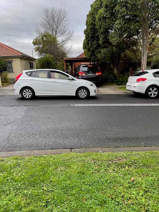 A car blocking a driveway.