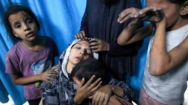 A wounded Palestinian woman from the Baraka family is surrounded by her children upon their arrival at Nasser Hospital in Khan Yunis in the southern Gaza Strip following Israeli air strikes that hit their building. Picture: AFP