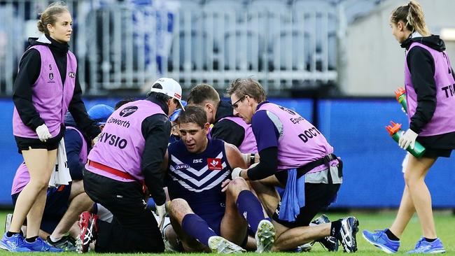 Dockers Aaron Sandilands is assisted off the field after colliding with North Melbourne’s Sam Durdin in Perth. Picture: Will Russell/Getty