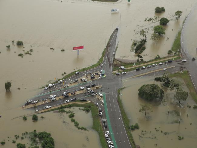 *This picture has been selected as one of the Best of the Year News images for 2019* Stranded vehicles are seen from above as floodwater engulfs the intersection of Stuart Drive and the Bruce Highway in Townsville, Monday, February 4, 2019. Hundreds of people still waiting for help and evacuation centres are filling up fast, with unprecedented water releases from the city's swollen dam having sent torrents of water down the Ross River and into the city, swamping roads, yards and homes. (AAP Image/Andrew Rankin) NO ARCHIVING