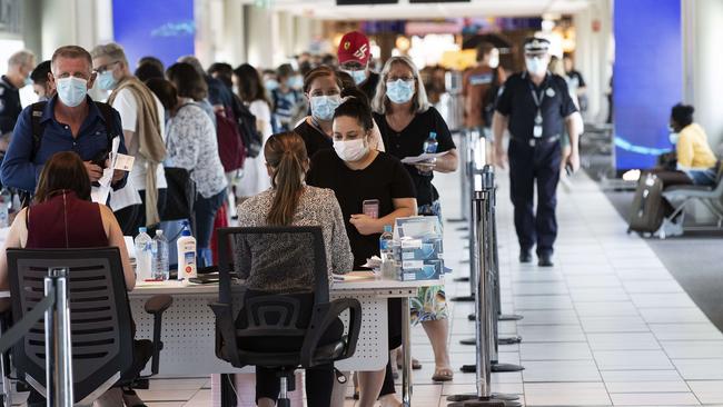 Travellers arrive from Sydney being checked by police upon arrival at Brisbane Domestic Airport. Picture: Attila Csaszar