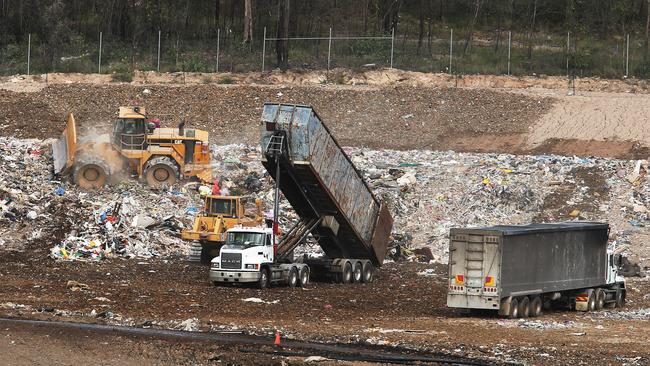 Trucks arrive and dump their loads of waste at the Wattle Glen landfill site, where Queensland has cheaper disposal rates than across the border in NSW