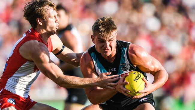 Port Adelaide’s Ollie Wines (centre) of the Power competes for possession against Callum Mills of the Swans during the Round 2 AFL match between the Sydney Swans and the Port Adelaide Power at the SCG.