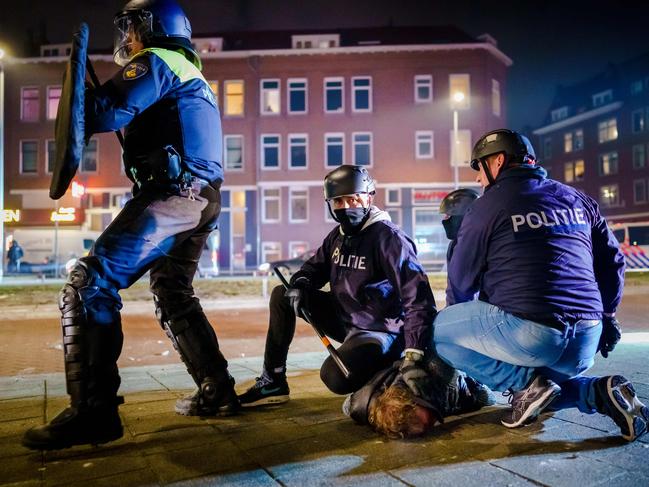 Dutch policemen arrest a man last month during clashes with a large group of young people in Rotterdam over the coronavirus curfew. Picture: AFP