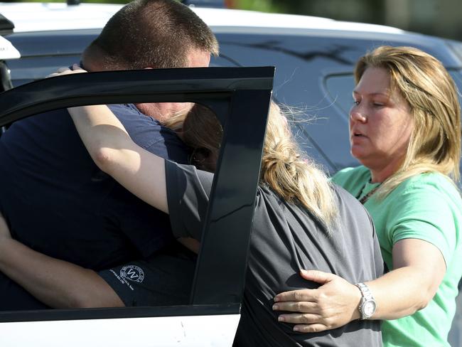 A Santa Fe Police officer consoles two women, with up to ten people killed and others injured in the gunfire. Picture: Jennifer Reynolds /The Galveston County Daily News via AP