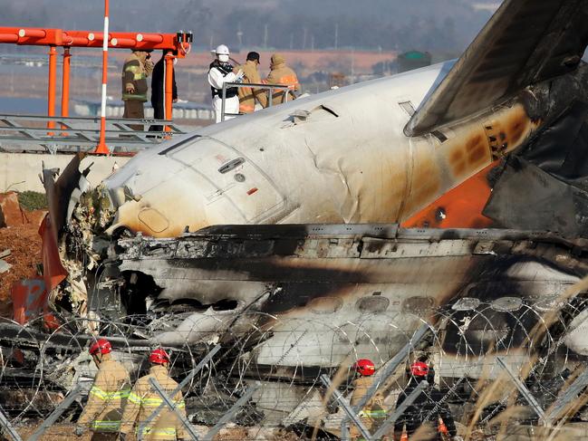 Firefighters and rescue teams work at the wreckage of the passenger plane at Muan International Airport. Picture: Getty Images