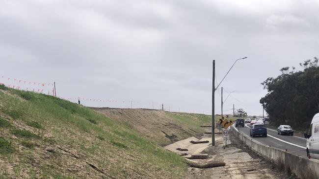 A section of the earthworks bank along Mona Vale Rd. A project insider claimed grit from the embankment was making the current road (right) slippery. Picture: Jim O’Rourke