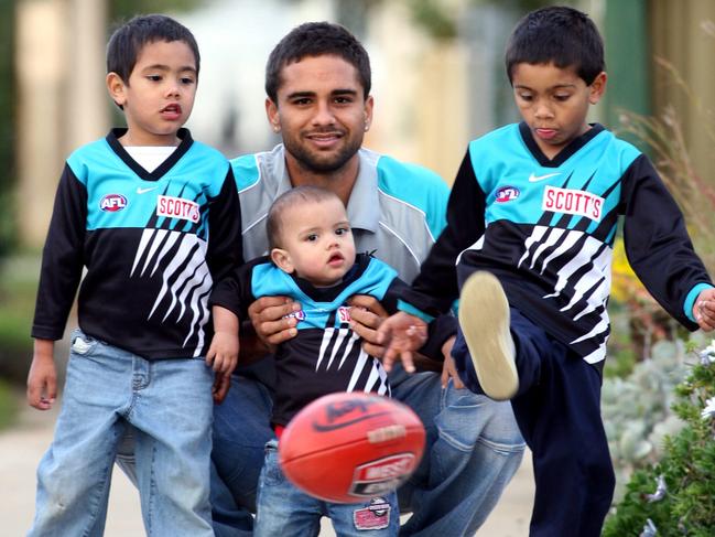 Port Adelaide champion Peter Burgoyne ahead of his 200th game with children Jase (then 4), Rome, 11 months, and Trent, 5.