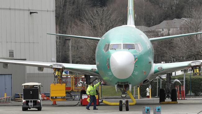 A worker stands near a Boeing 737 MAX 8 aeroplane parked at Boeing Co.'s Renton Assembly Plant. Picture: AP