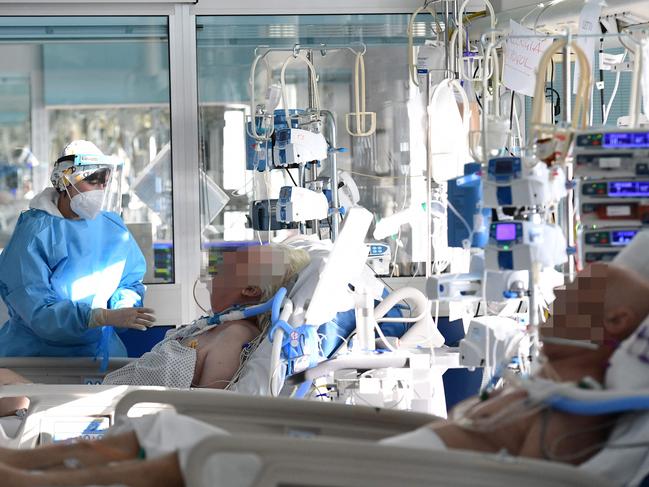 A medical staff member tends to a Covid-19 patient at the intensive care unit of Cremona hospital, in Cremona, northern Italy, on January 11, 2022. - Italy's Prime Minister Mario Draghi put the pressure back on the unvaccinated on January 10, 2022, calling them the cause of "most of the problems" in the country, which has been plagued by the spread of the Omicron variant. (Photo by Miguel MEDINA / AFP)