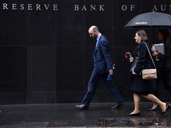 Pedestrians walks past the Reserve Bank of Australia in Sydney on June 4, 2019. - The Reserve Bank cut interest rates by 25 basis points to a historic low of 1.25 percent, as the pace of growth slowed to levels not seen since the global financial crisis. (Photo by PETER PARKS / AFP)