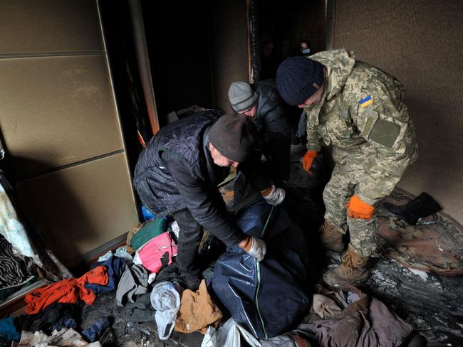 Rescuers collect the body of a woman from her house in the village of Andriivka, Kyiv region. Picture: AFP