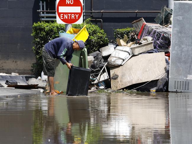 A man cleans up outside an inner-Brisbane factory in March.