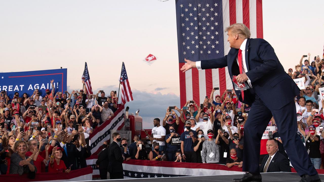 Donald Trump throws masks to supporters. Picture: Saul Loeb/AFP