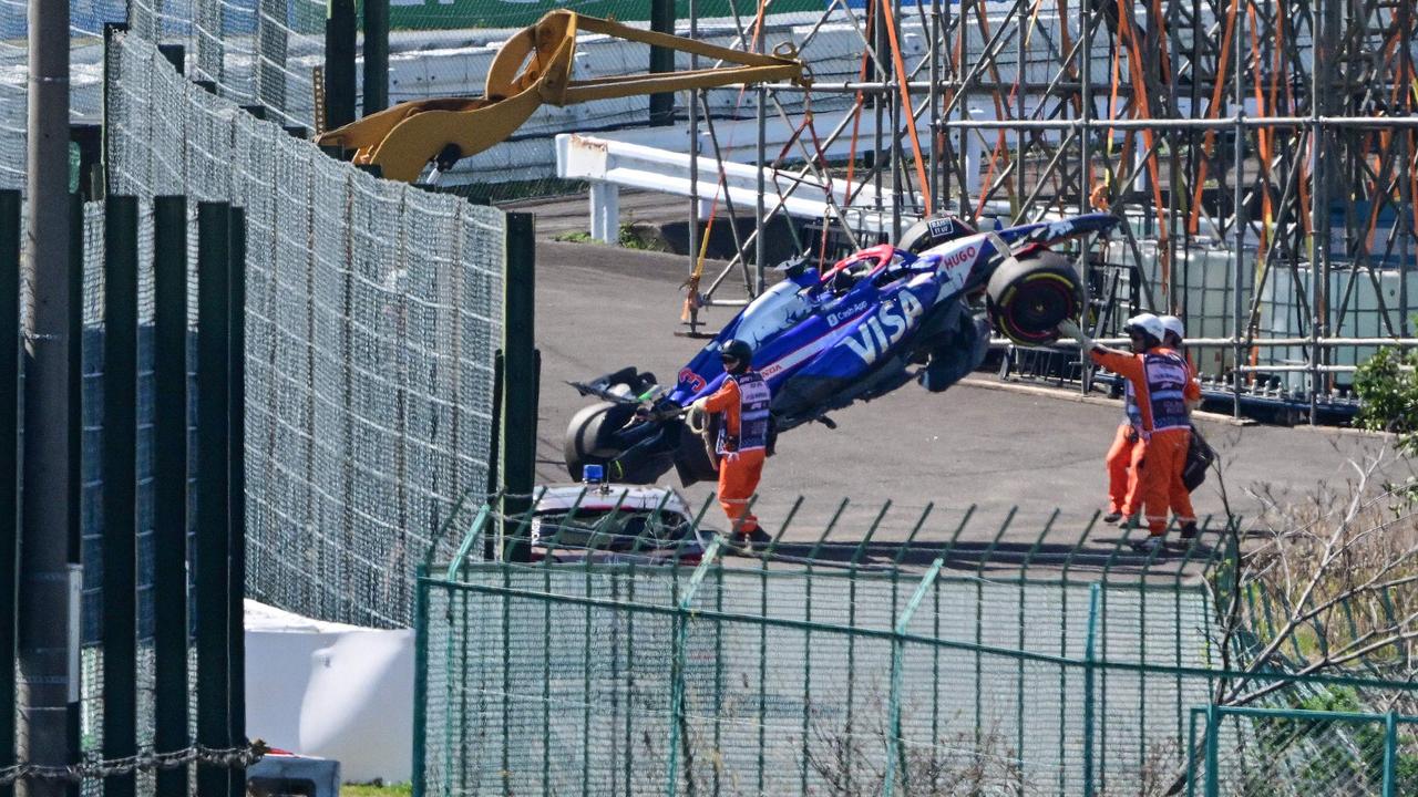 Officials remove Ricciardo’s car from the track. (Photo by Yuichi YAMAZAKI / AFP)