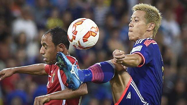 Jordan's Monther Abu Amara and Japan’s Keisuke Honda compete for the ball.