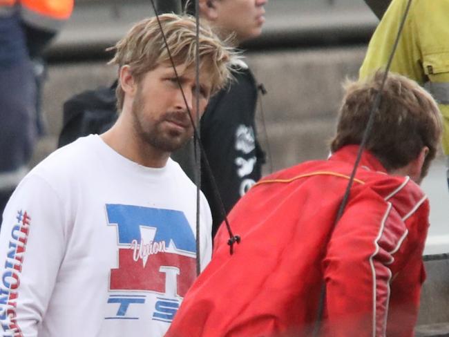 Images from the filming of the Fall Guy. Ryan Gosling wearing long sleeve white top. Stunt double wearing red jacket . Filming on the Sydney Harbour Bridge near Milsons Point Station. Picture: Bill Hearne