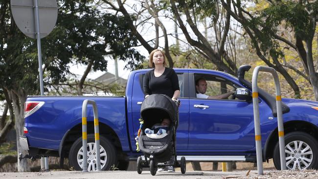 Georgina Gofton and son James at the pedestrian crossing near the Boundary/Rouen roads roundabout in Bardon. There has been a small win on upgrading MetRoad5. Picture: AAP/Regi Varghese