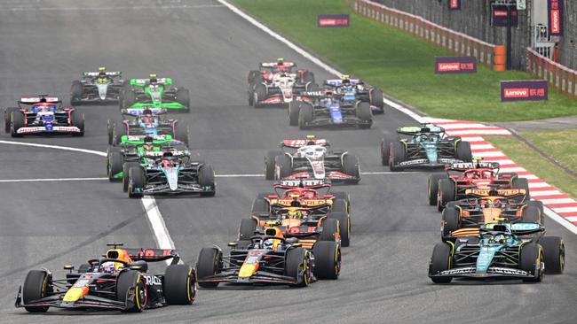 Red Bull's Max Verstappen (left) got away cleanly, but Fernando Alonso (right) was able to get past Sergio Perez at the start. (Photo by HECTOR RETAMAL / AFP)