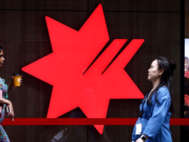 Pedestrians walk past the logo of National Australia Bank, on display outside a branch in central Sydney on November 7, 2024. National Australia Bank released its full-year financial results for 2024 on November 7. (Photo by DAVID GRAY / AFP)