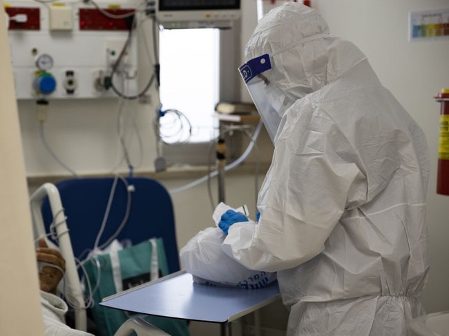 A health worker is seen as Israelis receive the third doses of coronavirus vaccines.