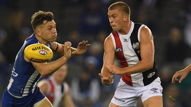 Seb Ross fires off a handball under pressure from Shaun Higgins.