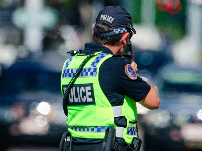 A generic photo of an NT Police Officer conducting a radar trap in a school zone on Cavenagh St Darwin.Picture: Glenn Campbell