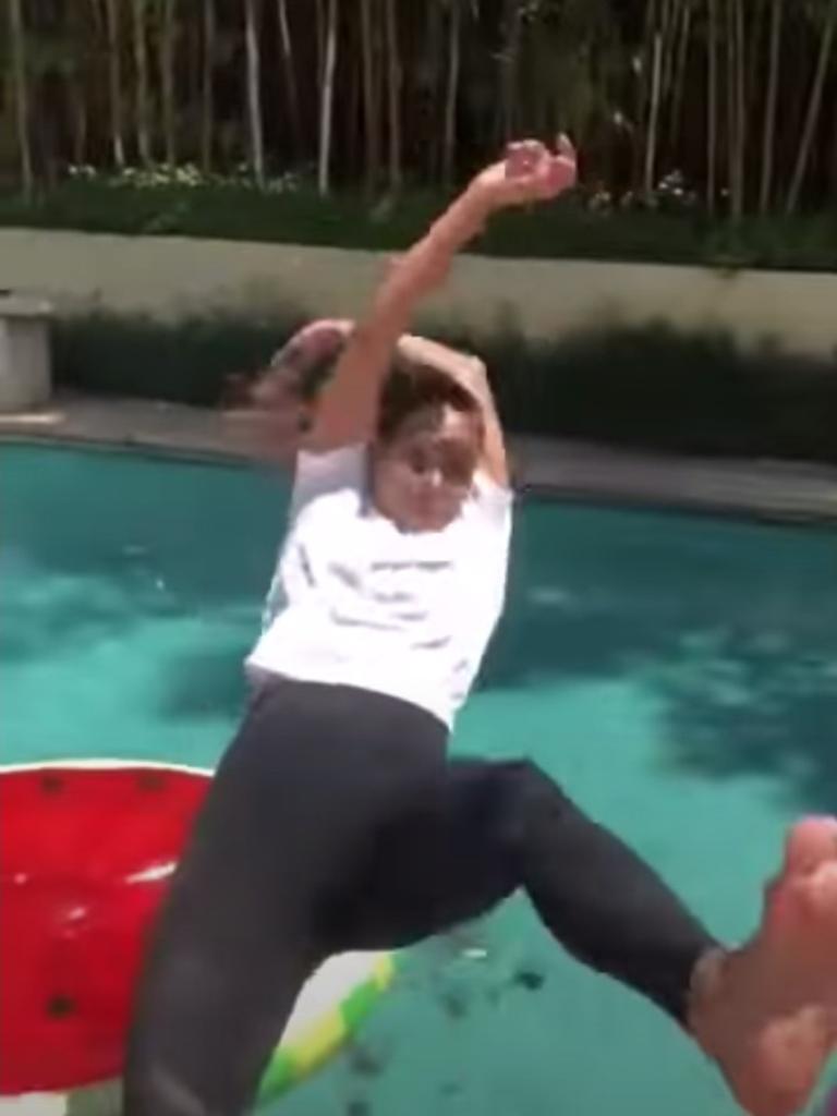 Halle Berry leaps backwards into a pool.