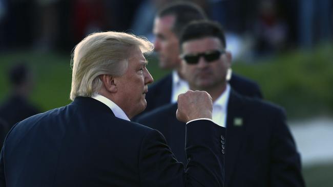 President Donald Trump gestures as he walks over to present the Presidents Cup to the United States.