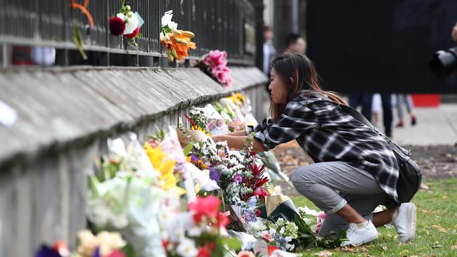 A woman lays flowers at a tribute to those who died in the Christchurch massacre. Picture: Getty