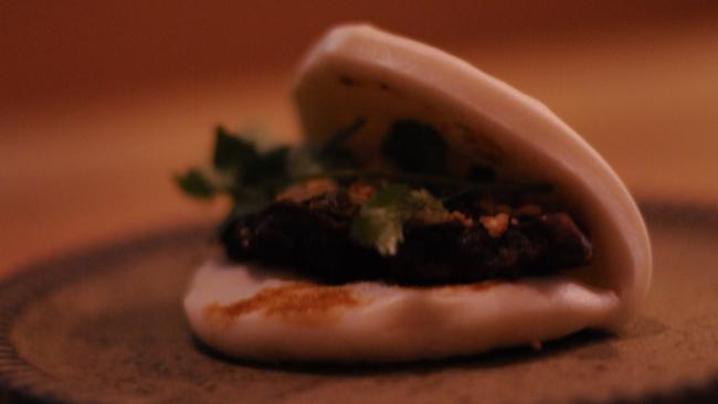 Braised five spice pork belly bao with pickled cabbage, peanuts and coriander.