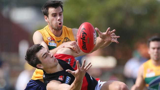 West Adelaide’s Brett Turner marks in front of Woodville-West Torrens’ Chris Hall. Picture: Stephen Laffer