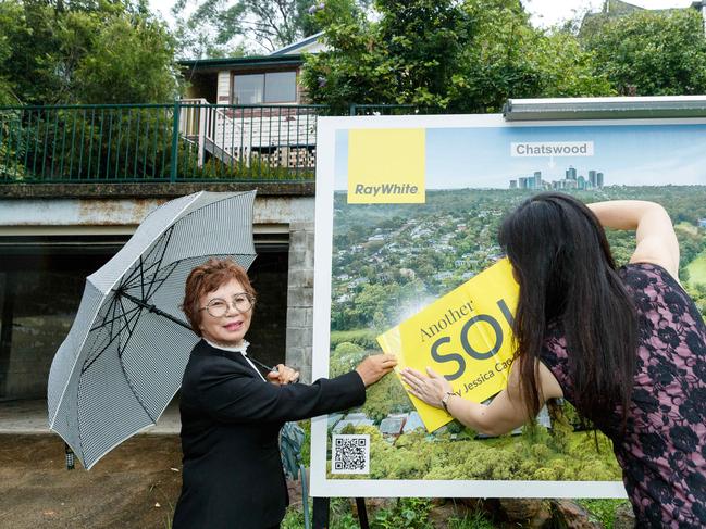 WEEKEND TELEGRAPHS. CHECK WITH JEFF DARMANIN BEFORE USE. Weekend auctions. 64 River Ave, Chatswood West. Pic shows winning bidder Min Hauri and agent Jessica Can putting a sold sticker on the sign. 10/02/2024. Picture by Max Mason-Hubers
