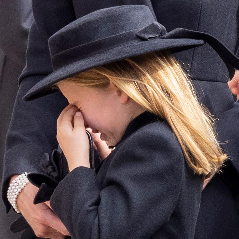 Princess Charlotte appears to cry. (Photo by Phil Harris / POOL / AFP)