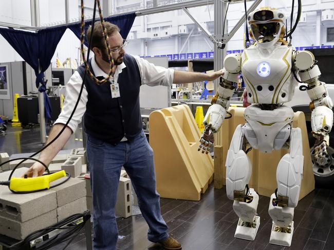 Gray Thomas, a NASA space technology research fellow, works with the Valkyrie humanoid robot. Picture: Michael Wyke