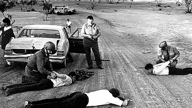 Police handcuffing three prison escapees who were captured on Birdsville Track on Sep 14 1970.  Men had taken Monica Schiller hostage after escaping from Cadell Training Centre.  kidnapping prison escapecrime 1970s