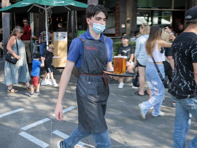 MELBOURNE, AUSTRALIA - NewsWire Photos MARCH 14, 2022:  A waiter delivers drinks to an outdoor table at a bar in Southbank.  The state government has  announced that casual workers will now be eligible to receive sick pay.Picture: NCA NewsWire / David Geraghty.