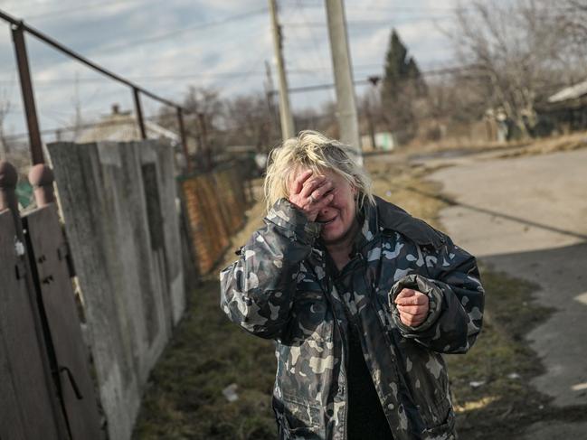 A woman reacts to the sound of shelling as she stands outside her house in the village of Chasiv Yar, near the city of Bakhmut. Picture: AFP