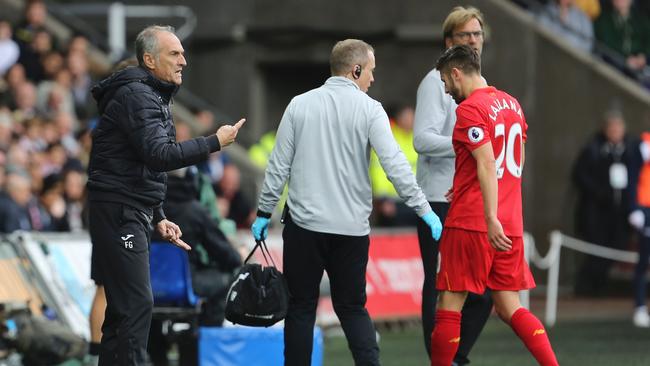 Liverpool's English midfielder Adam Lallana (R) leaves the pitch injured (R).