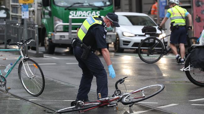 A policeman stops to pick up a protester’s bike. Picture: David Crosling