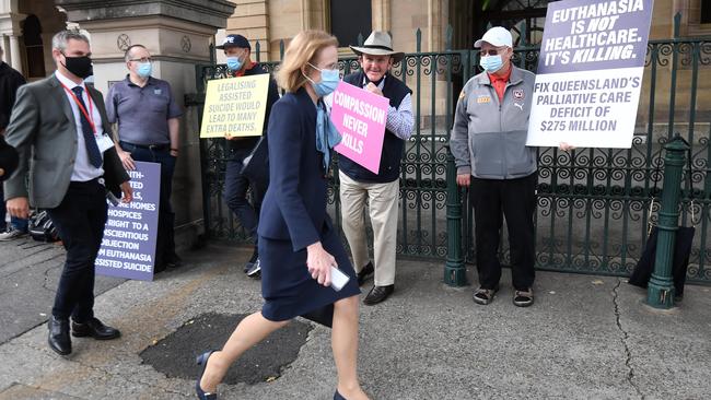 Chief health officer Dr Jeannette Young walks past an anti-euthanasia protest outside Parliament House in Brisbane. Picture: Dan Peled