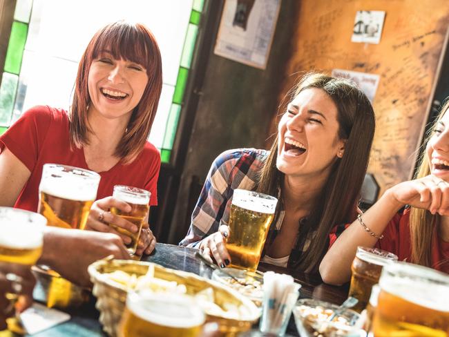 Happy girlfriends women group drinking beer at brewery bar restaurant - Friendship concept with young female friends enjoying time and having genuine fun at cool vintage pub - Focus on left girl