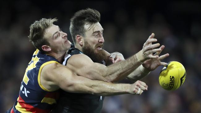 Adelaide’s Daniel Talia punches the ball away from Port’s Charlie Dixon. Picture: Sarah Reed