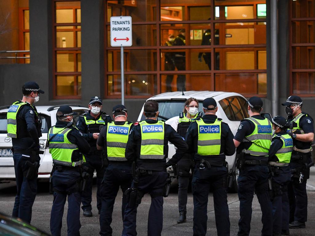 Police gather outside one of nine public housing estates which have been locked down in Melbourne. Picture: William West/AFP