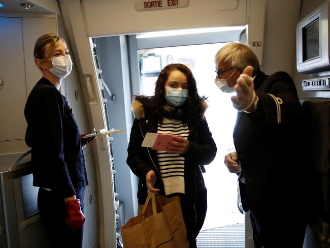 Passengers wearing protective face masks board an Air France flight to Mexico City at Paris Charles de Gaulle airport. Picture: Benoit Tessier